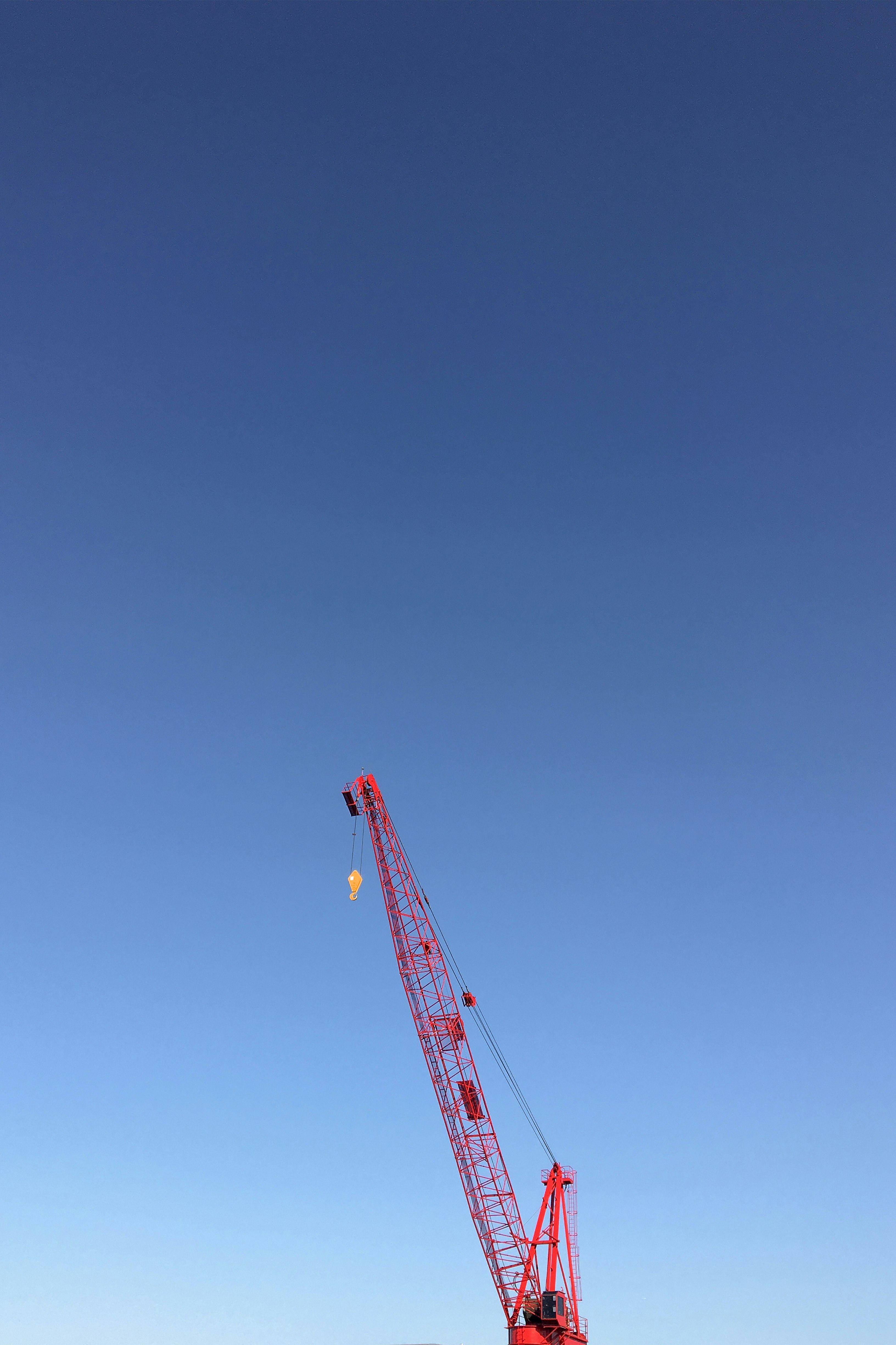 orange crane under blue sky during daytime